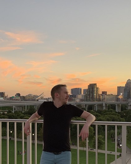 Matt, your host, on a balcony with the Louisville skyline at sunset